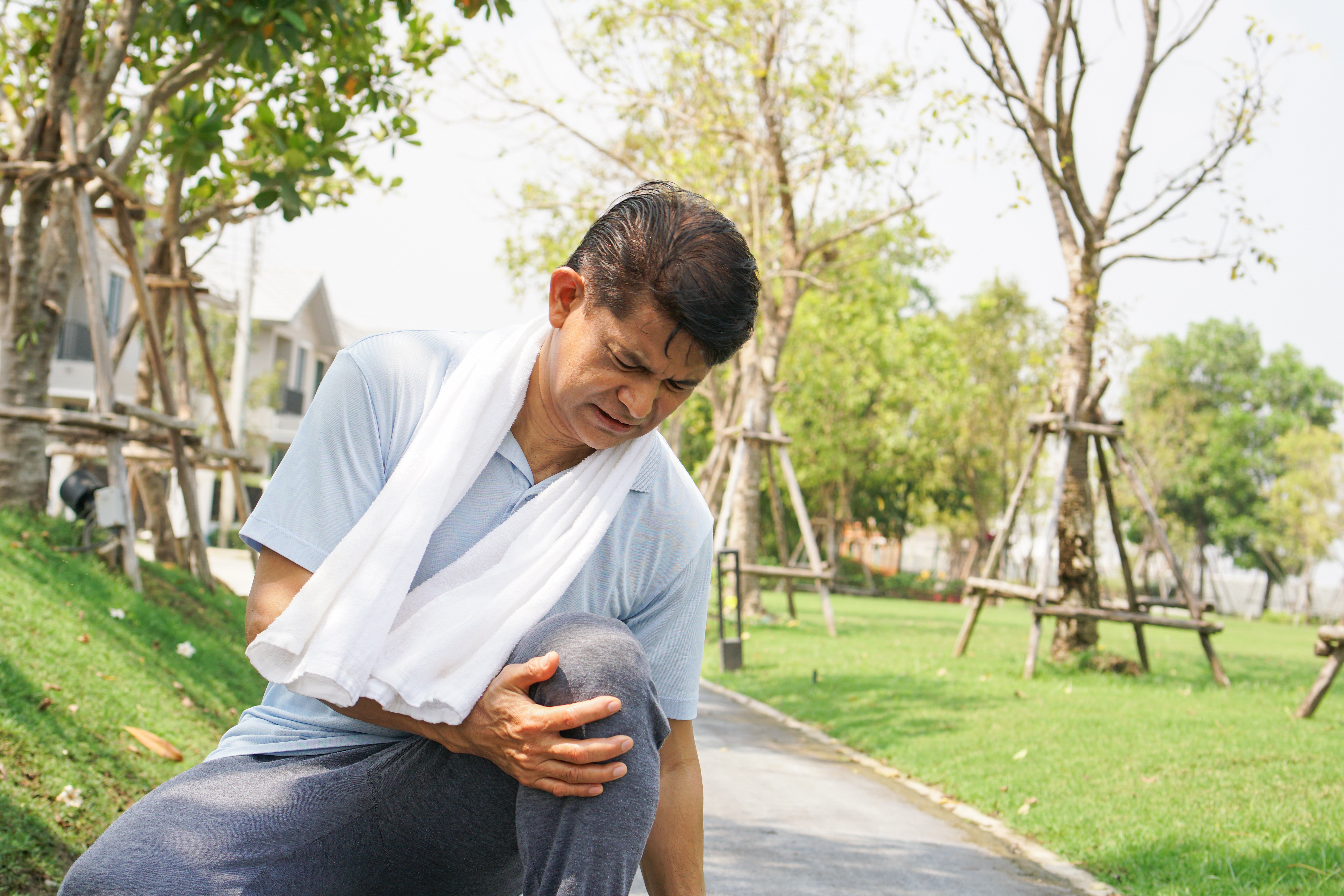 Asian senior man falling down and getting knee hurt