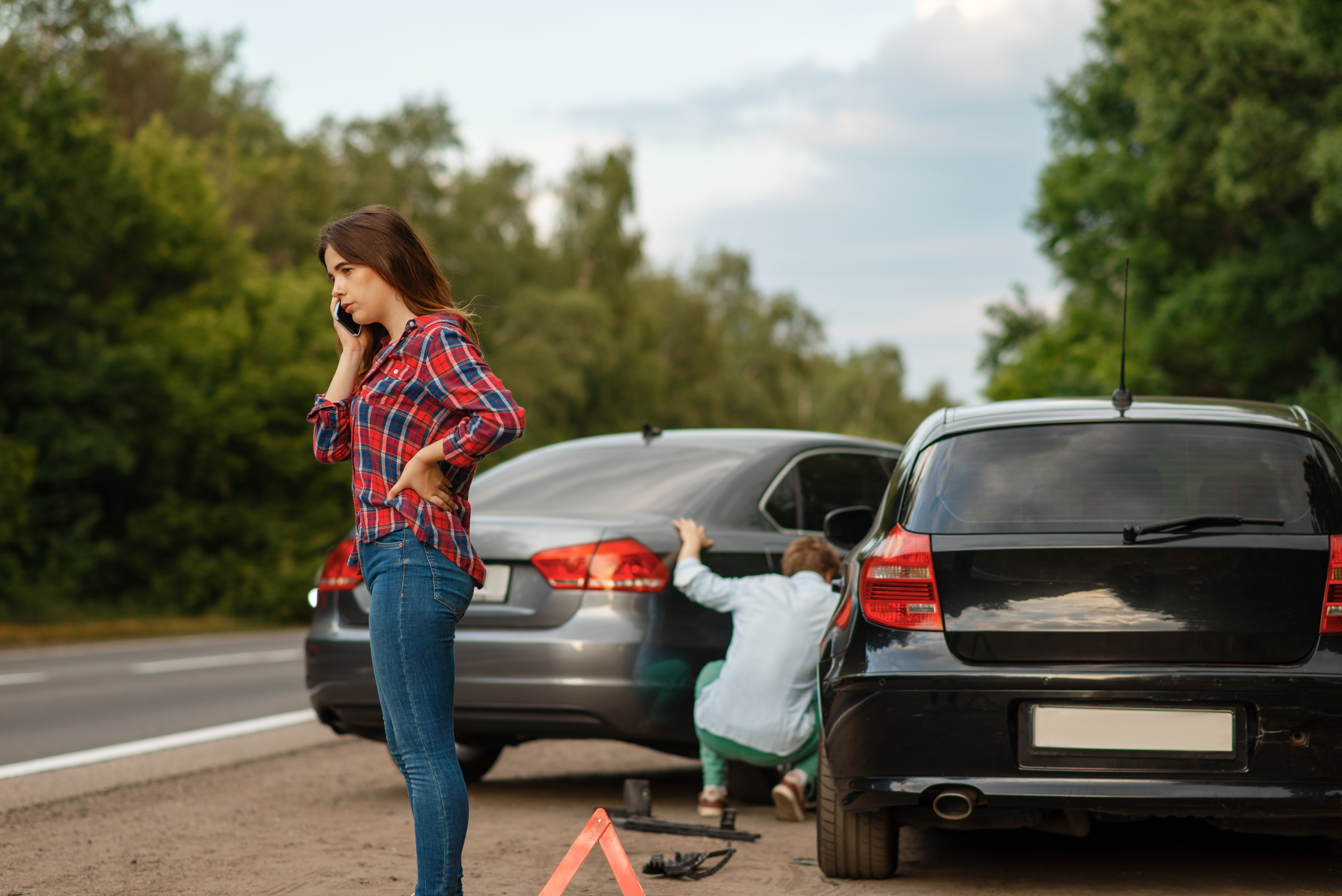 Male and female drivers on road, car accident